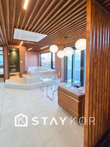 un hall d'entrée avec des tables en verre et une baignoire dans l'établissement Staykor Busan, à Pusan