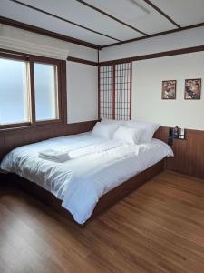Cette chambre comprend un grand lit et 2 fenêtres. dans l'établissement Staykor Busan, à Pusan