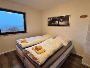 two beds in a room with a window at Haus Aktiv Garten2 in Winterberg
