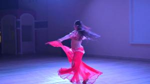 a woman in a red dress dancing on a stage at Oyster Bay Beach Suites K7-14 in Marsa Alam City +61 photos