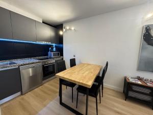 a kitchen and dining room with a wooden table and chairs at Puro Centro in Escaldes-Engordany