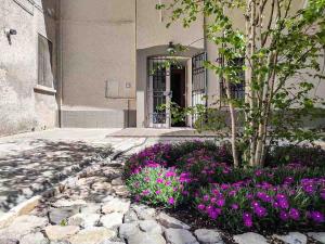 a building with purple flowers in front of a building at Tappetà perì in Campobasso