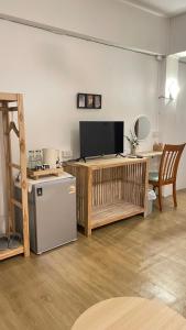 un soggiorno con televisione e tavolo di A Day Rayong a Ban Pa Khan