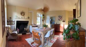 un soggiorno con tavolo e camino di Chez Mathé Longère Charentaise a Cercoux
