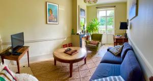 un soggiorno con un divano blu e un tavolo di Chez Mathé Longère Charentaise a Cercoux