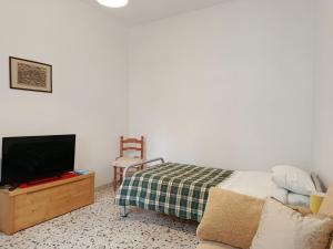 a bedroom with a bed and a tv and a chair at La Villetta in Vittorito