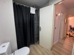 a bathroom with a toilet and a black shower curtain at Puro Centro in Escaldes-Engordany +10 photos