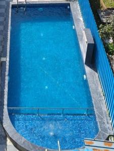 eine Draufsicht auf einen großen blauen Swimmingpool in der Unterkunft Vrindavan Hotel and Restaurant in Malavli