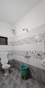 ein Badezimmer mit Toilette und Waschbecken in der Unterkunft Vrindavan Hotel and Restaurant in Malavli
