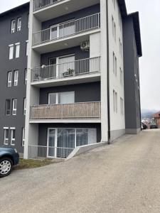 a building with balconies and a car parked in front of it at Mira in Čajetina