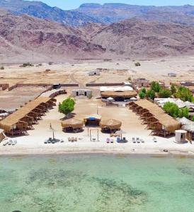 una vista aerea di una spiaggia con sedie e acqua di Relax Beach Camp a Nuweiba‘ el Muzeinah