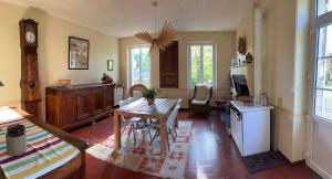 un soggiorno con un tavolo e una cucina di Chez Mathé Longère Charentaise a Cercoux Altre 12 foto