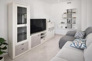 un soggiorno con un grande centro di intrattenimento bianco con televisore di Casa Rural Los Gaspares a La Carlota