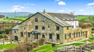 een oud stenen gebouw aan de zijkant van een heuvel bij Pyes Mill Hotel Conder Green in Conder Green