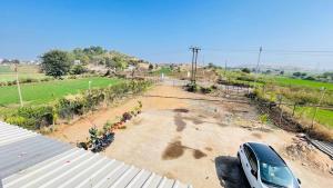 a car parked in a parking lot next to a field at Maa Rewa Palace in Sānāwad