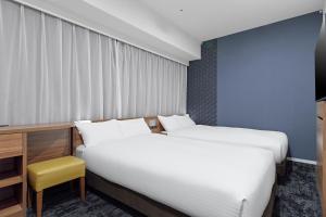 Postel nebo postele na pokoji v ubytování Sotetsu Fresa Inn Kitahama