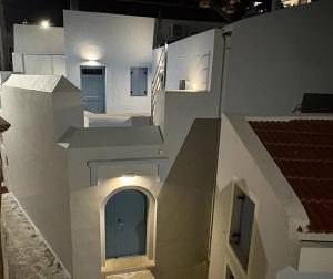 a white building with a door in the middle at Aleminas Rooms 2 in Symi +45 photos