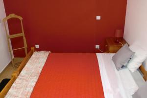 a bedroom with a bed with a red wall at The Yellow House in Vila Nova de Gaia