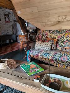 een woonkamer met een bank en een tafel bij Les petites marches in Saint-Benoît-du-Sault