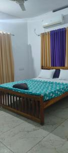 a large wooden bed in a room with curtains at Grape Garden in Varkala