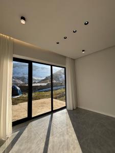 a room with a large window with a view at Shahdag Mountain Breeze in Qusar