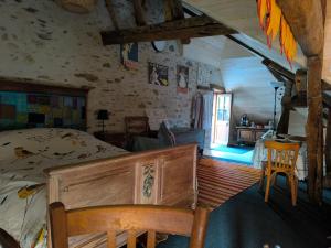 een slaapkamer met een bed, een tafel en een raam bij Les petites marches in Saint-Benoît-du-Sault