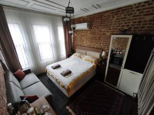 a bedroom with a bed and a couch and a brick wall at Fener sweet in Istanbul