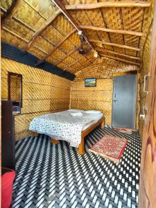een kamer met een bed en een tapijt op de vloer bij Dream Hampi Cottage in Hampi +25 foto's