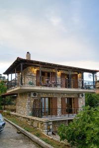 una casa in pietra con balcone sopra di Villa-Τo Petrino a Krionérion