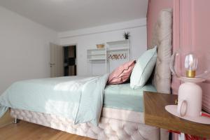 een slaapkamer met een bed met kussens en een tafel bij Apartman Mia in Čačak