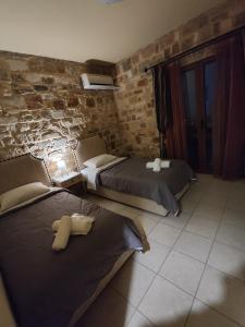 una camera da letto con due letti e un muro di mattoni di Villa-Τo Petrino a Krionérion