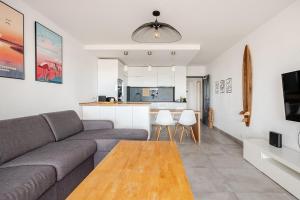 a living room with a couch and a table at Le Plein Sud in Le Grau-du-Roi