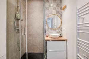 a bathroom with a shower with a sink and a mirror at Le Plein Sud in Le Grau-du-Roi +15 photos