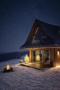 una casa nella neve di notte con un camino di NOOK Cabins - Mountain View a Zakopane