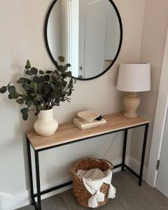 een tafel met een spiegel en een lamp en een plant bij Fribourg Studio Home in Fribourg