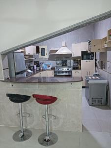 a kitchen with a counter and two bar stools at noreno houseاسوان شياخة تانية طريق السادات in Aswan