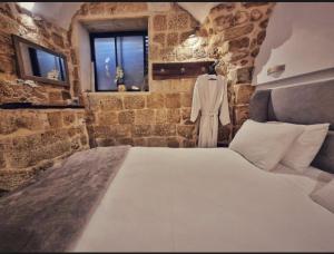 a bedroom with a large bed in a stone room at Akotika boutique in Acre