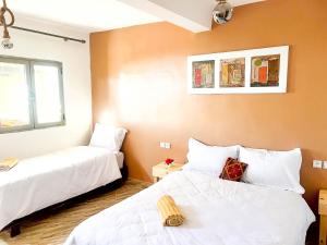 two beds in a room with white sheets at Superbo Stay Sea View Surf House near Taghazout Panoramic Terrace in Taghazout