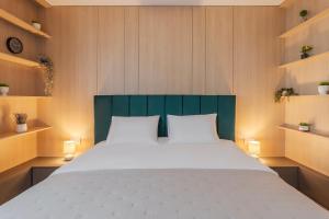 a bedroom with a large bed with a green headboard at Velour Suites in Oradea