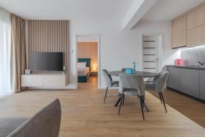 a kitchen and living room with a table and chairs at Velour Suites in Oradea