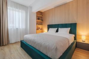 a bedroom with a large bed and a window at Velour Suites in Oradea