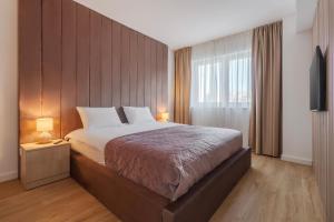 a bedroom with a large bed and a window at Velour Suites in Oradea