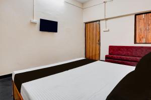 um quarto com uma cama e um sofá vermelho em Hotel O by OYO RASRANG em Raipur