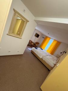 een zolderkamer met een bed en een raam bij Leos und Armando Gjuci GbR in Großpostwitz