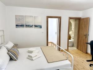 una camera da letto bianca con un letto e asciugamani di Nomas Home Kalyves a Kalyves