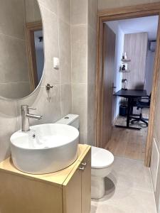 un bagno con lavandino, WC e specchio di Nomas Home Kalyves a Kalyves