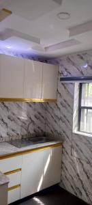 a kitchen with white cabinets and a window at 517 VIP suites and apartments in Awka