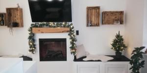 een woonkamer met een open haard, een televisie en een kerstboom bij Seeloft in Gmunden