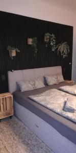 een groot bed in een kamer met een zwarte muur bij Seeloft in Gmunden