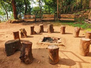 eine Gruppe von Baumstämmen und eine Feuerstelle in einem Park in der Unterkunft rigel home stays in Jāmb
